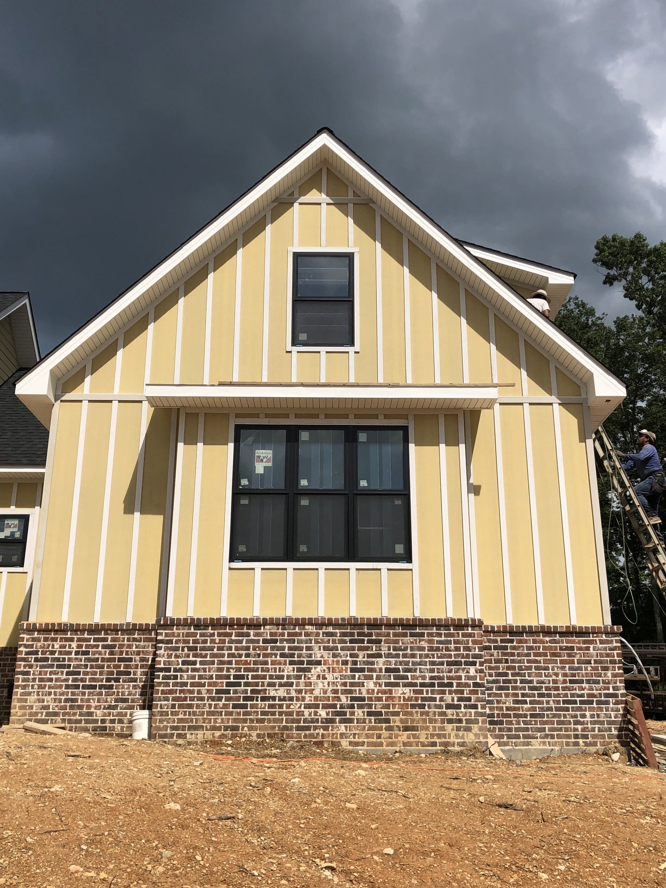 Yellow board-and-batten gable with new windows